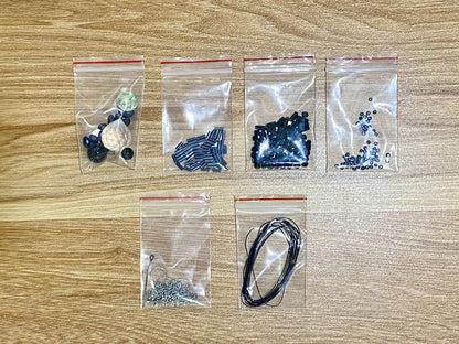 Black Widow Suncatcher DIY Kit - materials laid out (Black)